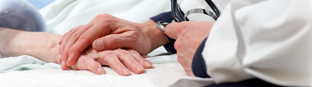 A close up of a doctor putting their hand on their patient's hand supportively