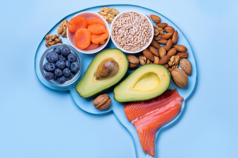 A brain shape made from healthy foods from the MIND diet, like avocado, salmon, nuts, fruits and vegetables